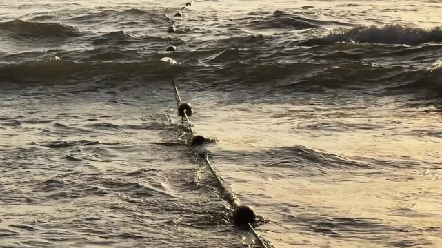 Safety Buoy Line Rope in sea Waves at the beach. Swimming zone boundary marker