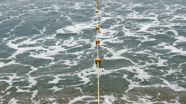 Safety Buoy Line in Rough Surf Waves. Rip current Beach Swimming Restriction