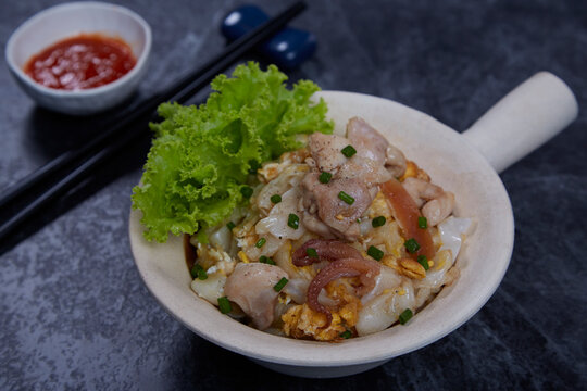 Stir-fried Fresh Rice-flour Noodles With Chicken, Cuttlefish And Egg on stone background.
