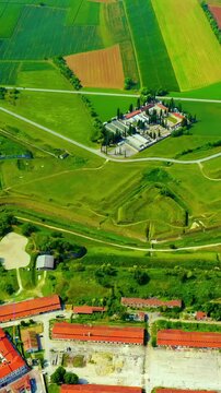 Vertical video. Palmanova, Udine, Italy. Drone footage of the nine-pointed star fortress, its concentric ramparts and geometric bastions visible from above amid green fields. Drone footage. Rich colo