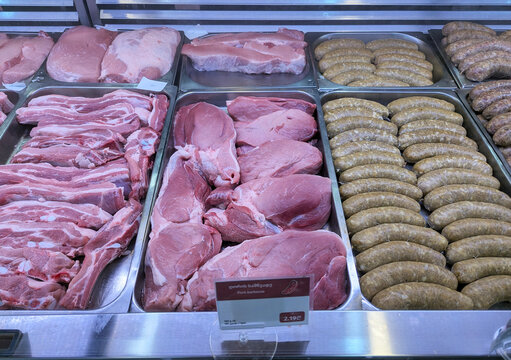 Raw meat and sausages in grocery store deli counter