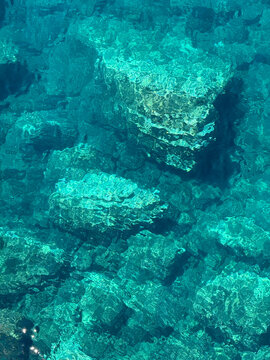 Azure blue sea water with rocky seabed vetical