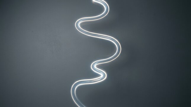 Glowing white light trail winding across a dark slate grey background with copy space for digital entertainment and streaming media campaigns