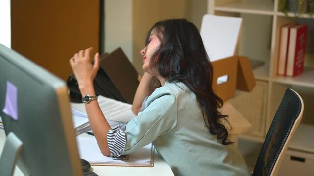 Stressed Businesswoman Covering Face at Office Desk Overwhelmed by Work and Paperwork