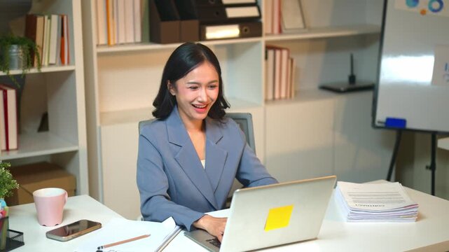 Businesswoman Working at Desk Checks Laptop Before Receiving Exciting Salary Bonus Notification in Modern Office