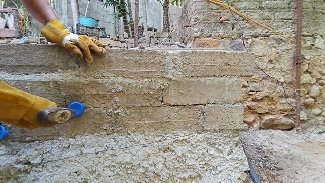 Securing wire mesh to wall using a nail and a recycled plastic bottle cap