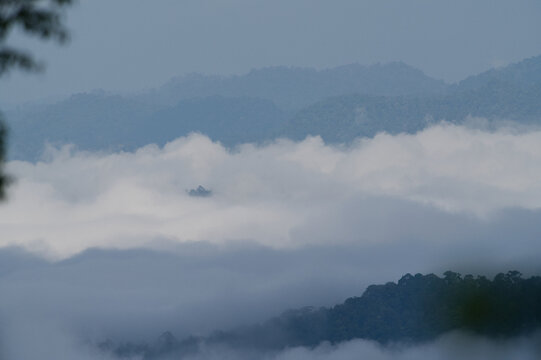Breathtaking aerial view of misty valleys and lush green tropical rainforest mountains at dawn