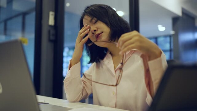 Young Asian woman working at office and have a pain office syndrome and tried after working 