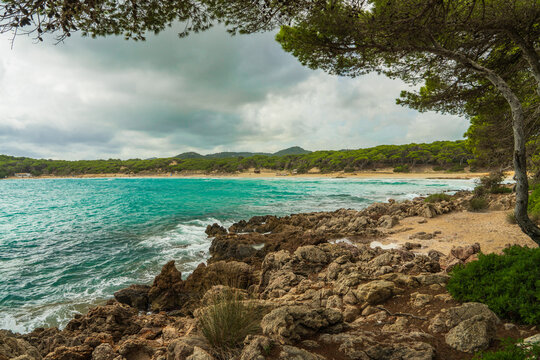Turquoise waters and beautiful sandy beach of Cala Agulla in Mallorca, Spain. Mediterranean coastline, crystal clear sea, scenic landscape, summer vacation, travel destination.