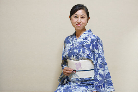 浴衣を着て帯留に手をやるシニア女性 カメラ目線