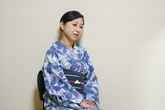 浴衣を着た淋しそうなシニア女性　黒い帯と帯留