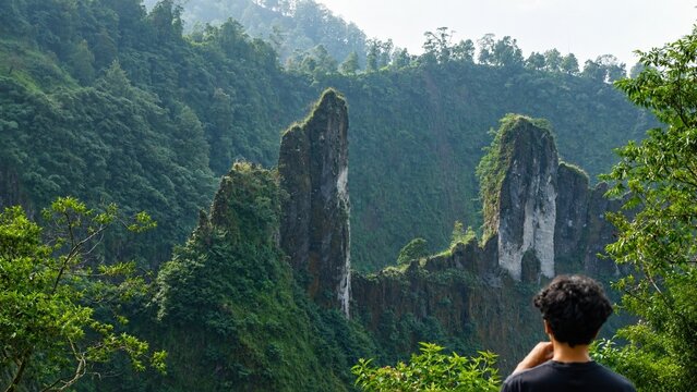 natural landscape view of rock formations at the foot of a mountain with people facing away from the camera or in a candid pose