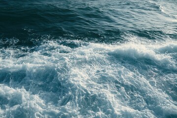 Naklejka premium Deep blue ocean swells cresting into white, foamy waves under natural light
