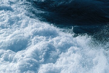 Naklejka premium Foamy, turbulent ocean waves crash with spray against deep blue water