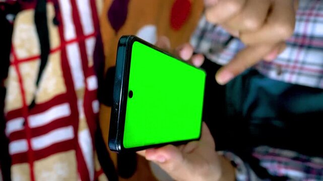 Person Holding A Modern Smartphone With A Green Screen Display For Custom Content Replacement