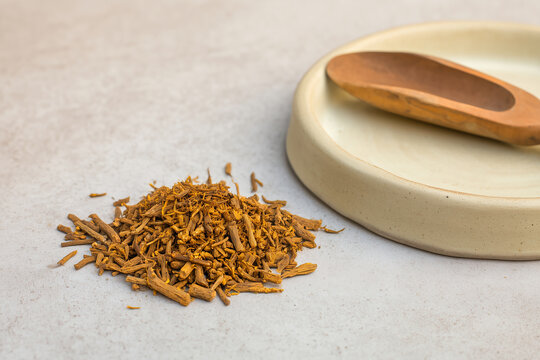 Chopped giloy guduchi stem wellness flatlay in warm amber gold tones on warm concrete surface with copy space