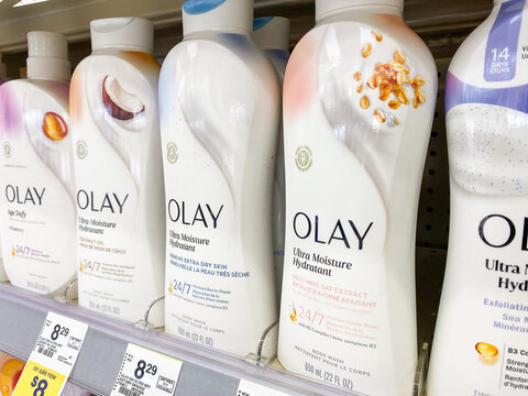 Row of Olay Ultra Moisture body wash bottles on a drugstore shelf close up view with price tag