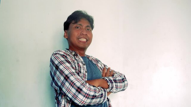 Young Man Wearing Plaid Shirt Smiling And Posing In Front Of A White Background Indoor Setting
