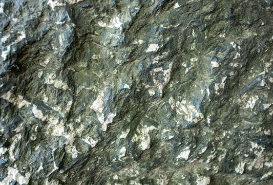 Close up view of textured surface of serpentinite or serpentine with mineral patterns and colors