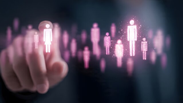 Human finger activating glowing holographic projection of digital human silhouettes in network structure representing data connectivity workforce analytics background.
