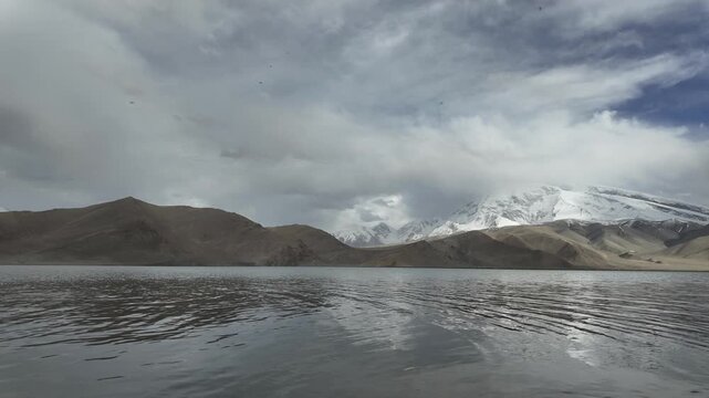 Scenic view of Muztagh Ata snow mountain reflection in dark waters of Karakul Lake Xinjiang China