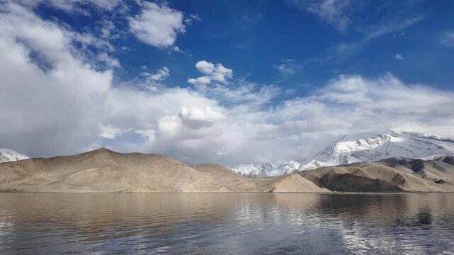 Scenic view of Muztagh Ata snow mountain reflection in dark waters of Karakul Lake Xinjiang China