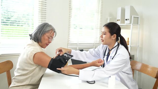 Doctor recording medical notes during a consultation with a senior patient in a modern clinic, supporting personalized healthcare and wellness.