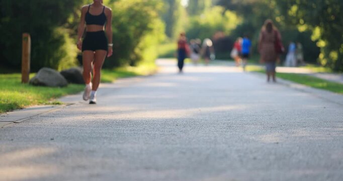 Unrecognizable people walking on the streets of Warsaw. People walking in the park. Sunny, hot, summer weather.