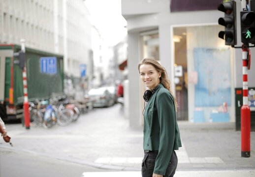 Young woman looks over shoulder smiling in city