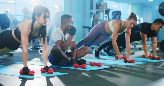 A dynamic group of individuals engaged in a workout session in a modern gym environment
