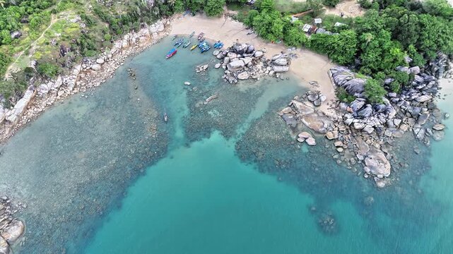 Spectacular Drone View of Turun Aban Beach with Granite Boulders, Coral Reef, Fishing Boats and Crystal Clear Tropical Water in Bangka Island