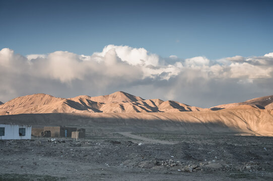 The high-mountain village of Bulunkul in the Tien Shan Mountains in the Pamirs of Tajikistan one-story houses of local residents in the evening against the backdrop of mountain ranges