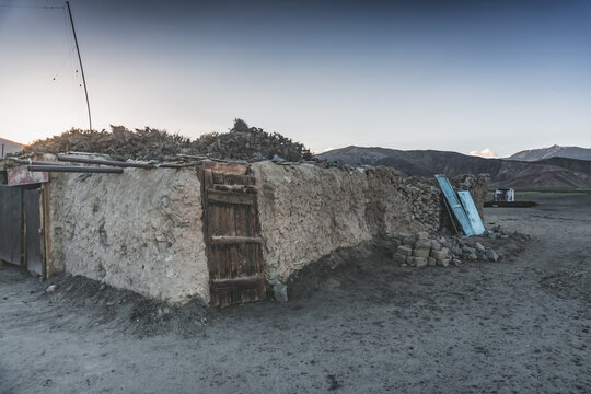 The high-mountain village of Bulunkul in the Tien Shan Mountains in the Pamirs of Tajikistan one-story houses of local residents in the evening against the backdrop of mountain ranges