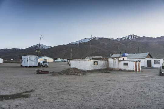 The high-mountain village of Bulunkul in the Tien Shan Mountains in the Pamirs of Tajikistan one-story houses of local residents in the evening against the backdrop of mountain ranges