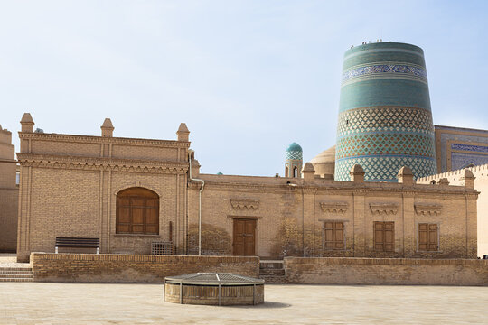 Kalta Minor minaret rising above brick buildings in the empty courtyard of Ichan Kala in Khiva, Uzbekistan. Ideal for travel guides, tourism brochures, and cultural heritage publications.