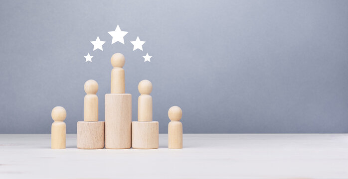 Top rating and business achievement concept with wooden human figures on a pedestal.