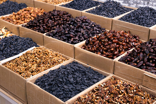 Dried fruits and walnuts displayed in cardboard boxes at an oriental bazaar in Bukhara, Uzbekistan. Ideal for travel, food, and cultural content.