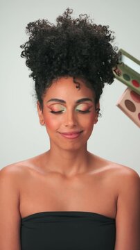 Dubai, UAE - 7 10 2023: Professional make-up master applies paint to a young model with curly hair