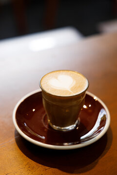 Glass of milk latte coffee on a wooden table.