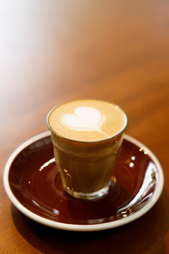 Glass of milk latte coffee on a wooden table.