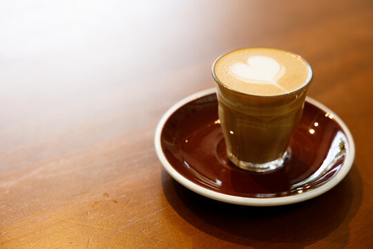 Glass of milk latte coffee on a wooden table.