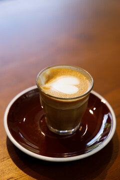Glass of milk latte coffee on a wooden table.