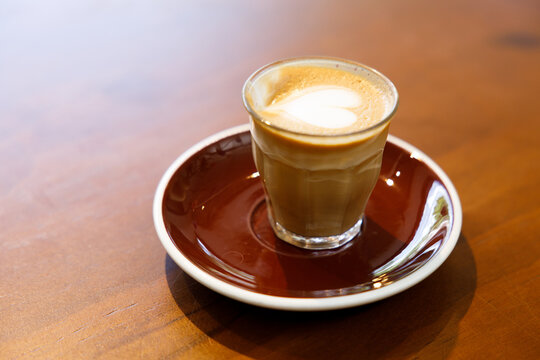 Glass of milk latte coffee on a wooden table.