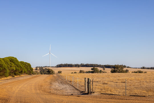 Dirt road heading to a countryside wind turbine