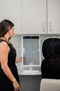 Aesthetics practitioner doing skin analysis during client consultation