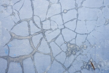 Weathered blue concrete surface featuring cracked paint and distressed texture, ideal as a rustic abstract background for design projects. © Sije