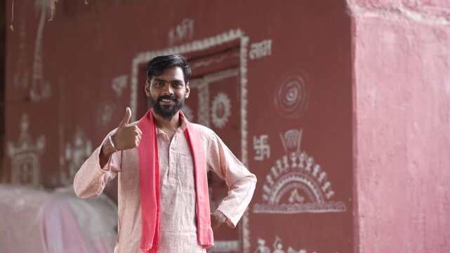 Young indian farmer showing thumps up at home 