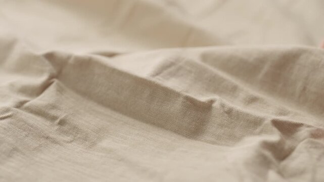 Slow motion man hand checking natural cotton jersey cloth
