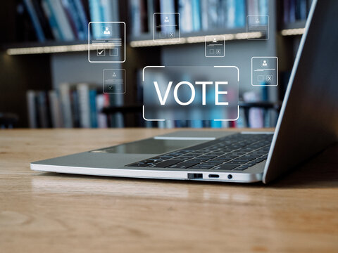 Online vote button over laptop keyboard in library workspace conveying civic engagement and digital polling empowerment