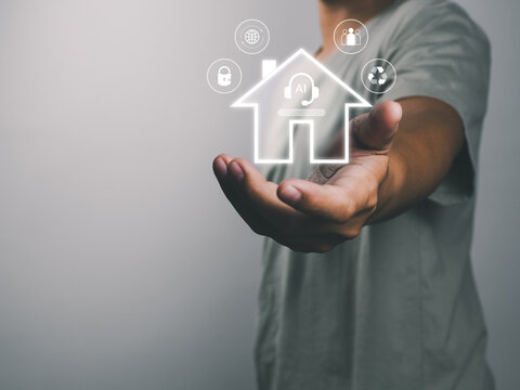 Smart home concept with glowing house icon and connected technology symbols held above outstretched hand conveying innovation and security